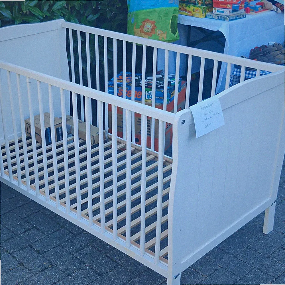 Weißes Kinderbett aus Holz mit Gitterstäben. Auch ohne Gitterstäbe verwendbar.